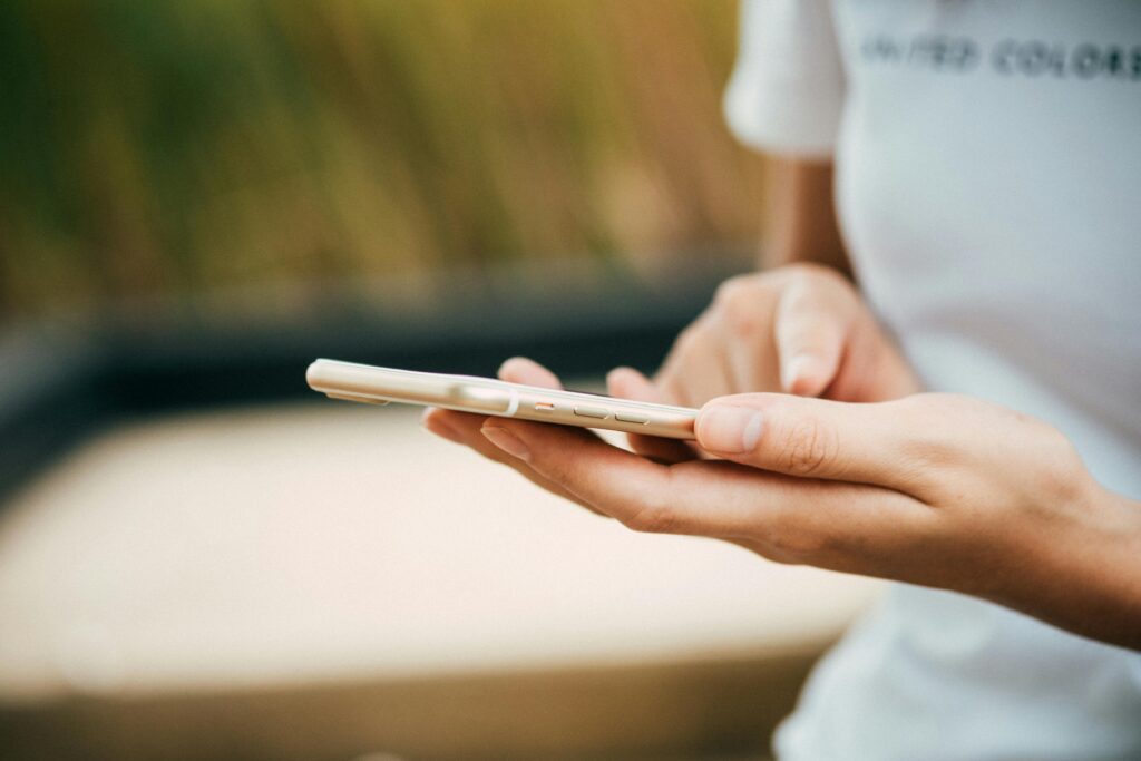 pexels-photo-369376-369376 Close-up of a person using a smartphone outdoors, focusing on hands and device.